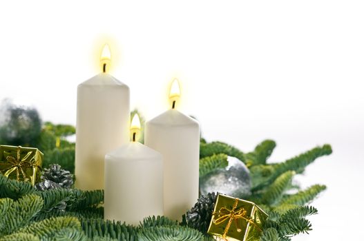 Three candles in advent setting with real Christmas tree branches