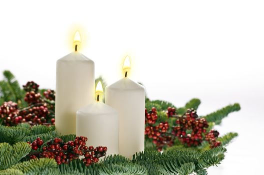 Three candles in advent setting with real Christmas tree branches