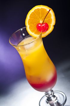 Tequila sunrise Cocktail in front of different colored backgrounds