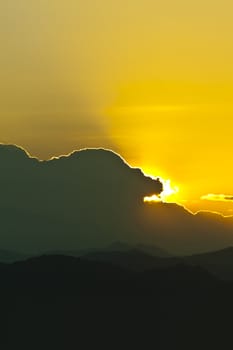 Sunset behind mountains with golden color