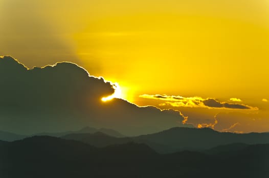 Sunset behind mountains with golden color