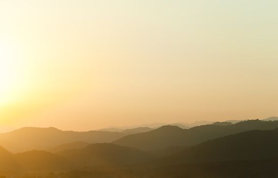 Sunset behind mountains with golden color