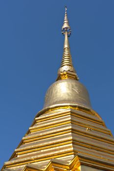 Golden roof of a temple in Thailand under blue sky