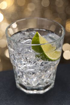 Gin Tonic Cocktail in front of a brown gold background