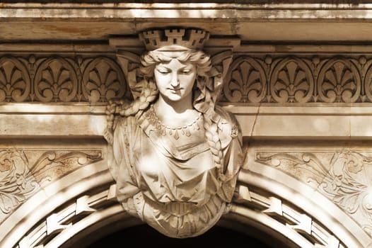 Sandstone woman figure as exterior decoration above an entrance