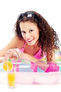 Smiled curl girl with sun glasses in hair, laying air mattress and drinking juice, isolated on white