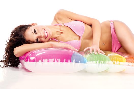Smiled curl hair girl in bikini laying on air mattress on white background