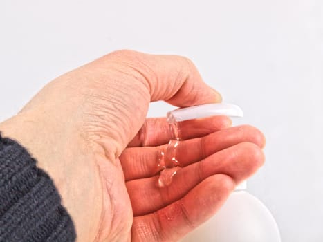 Person taking antibacterial liquid from a pump bottle