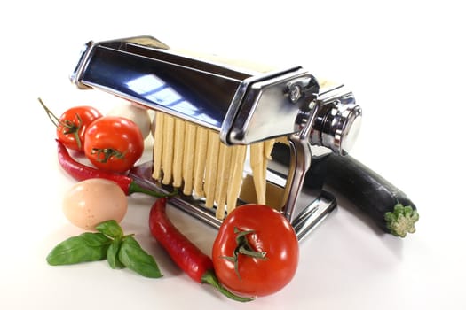 tagliatelle in a pasta machine with tomatoes, chili and basil
