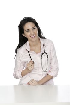 Beautiful young doctor sat smiling at her work desk