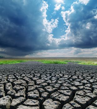 cracked earth under stormy clouds. global warming