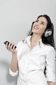 Attractive young woman listening to music with headphones from her mobile phone