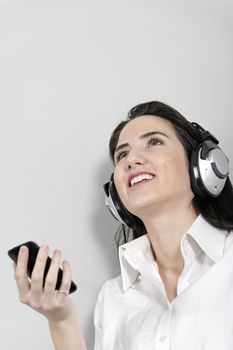 Attractive young woman listening to music with headphones from her mobile phone