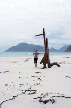 Woman standing at Shipwreck Kakapo at the beach of kommetjie with upcoming storm in the background