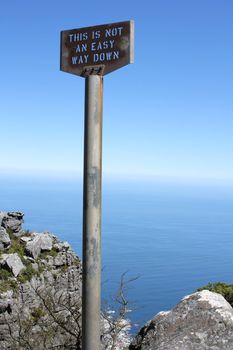 Old signpost on table mountain saying this is not an easy way down