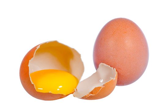 close up on two raw eggs, one broken, one whole isolated on white background