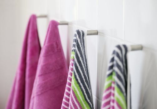 Clean new towels hanging in a bathroom.