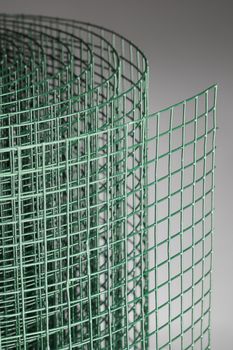 Coated green metallic wire mesh used in gardening by protecting plants from animals.