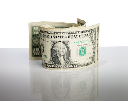 Worn old US Dollar paper money on reflective background.