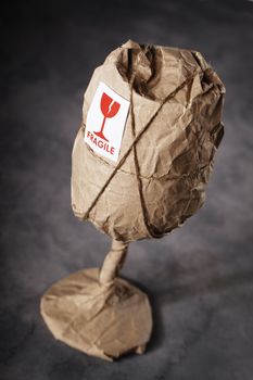 A Wine glass packaged in brown wrapping paper with "Fragile" warning sticker.