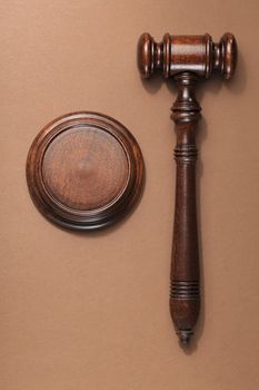 A wooden mahogany gavel with sound block on brown background.