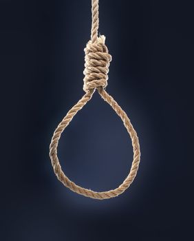Rope noose with hangman's knot hanging in front of blue background.