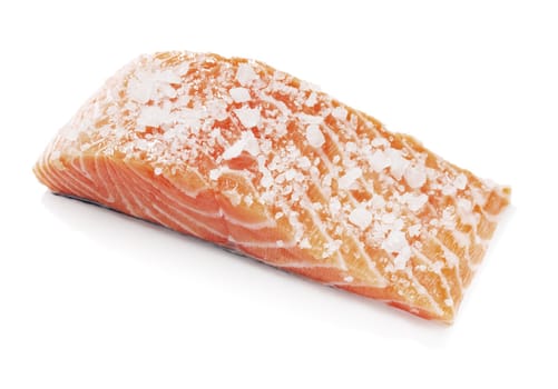 Salmon fish fillet salted with coarse salt. Isolated on white with natural shadows.