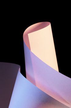 Abstract image of white paper sheets photographed under color lights.