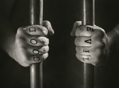 Man with (fake) Good and Evil tattoos behind prison bars.