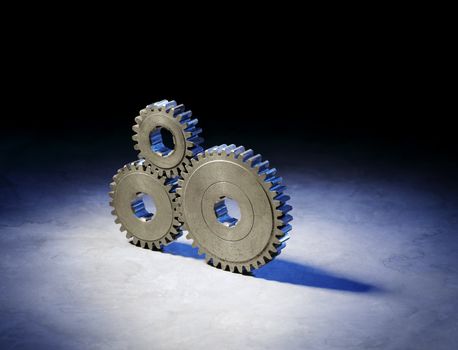 Still life with three old metallic cog gear wheels.