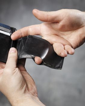 Man showing a hole in the coin pocket of his wallet.