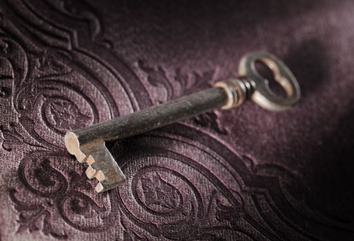 Old key on an ornamental 19th century book cover.