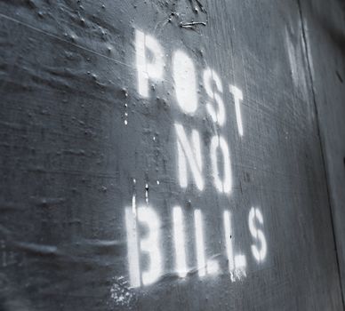 Words "Post No Bills" sprayed on an old wall.
