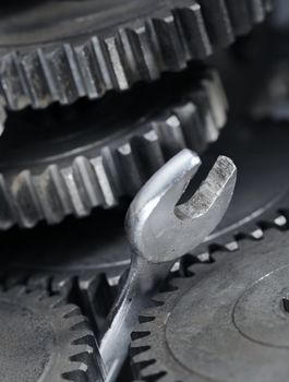 A Spanner Wrench stuck between cog gear wheels. 