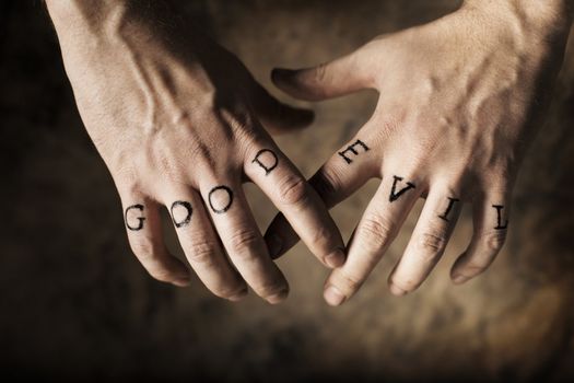 Man with Good and Evil (fake) tattoos on his hands.