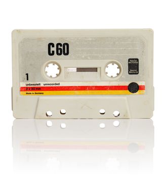 Vintage compact cassette audio tape on white with natural reflection.