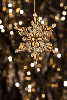 Artificial Snowflake in gold shining over a golden background