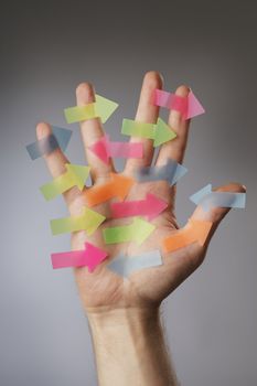 Hand with adhesive arrows at different directions