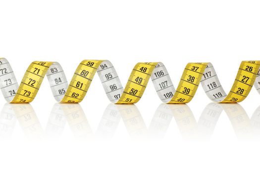 Yellow and white metric tape measure on white reflecting background