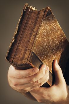 Hands holding an important old book