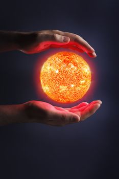 A Glowing sun between hands. Sun images provided by NASA.