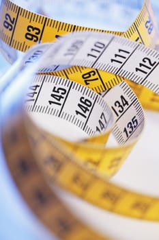 A Yellow and white metric tape measure in closeup.