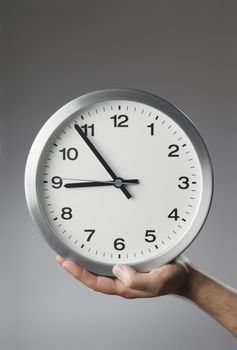 Man holding a clock in his hand.