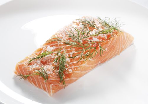 salt and sugar cured salmon, scandinavian cuisine called "gravlax" on a white plate.