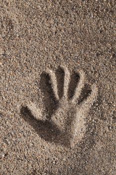 Hand print in coarse sand.