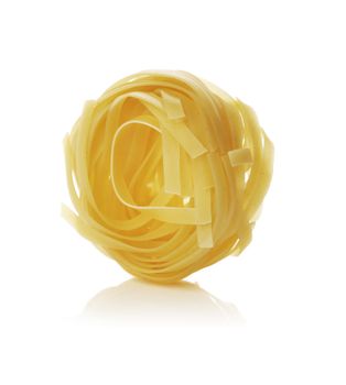 Dried taglieatelle ribbon pasta shape isolated on white with reflection.