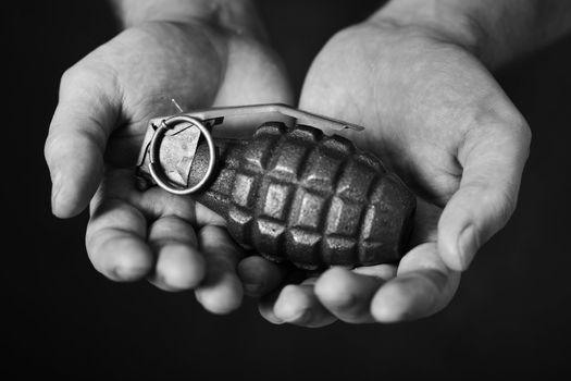 Man holding an old hand grenade in his hands