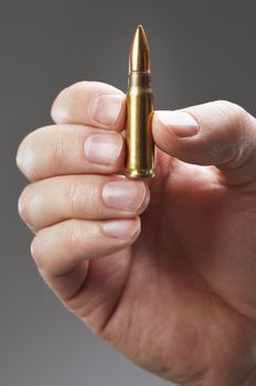 Hand holding an assault rifle cartridge
