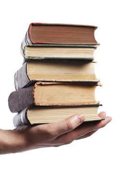 Man carrying a stack of old books in his hands