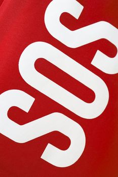 SOS ("save our souls") lettering on a red fabric first aid kit